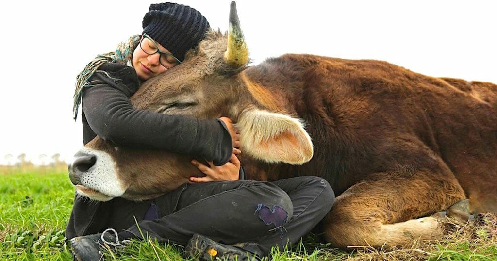 mujer abrazando una vaca